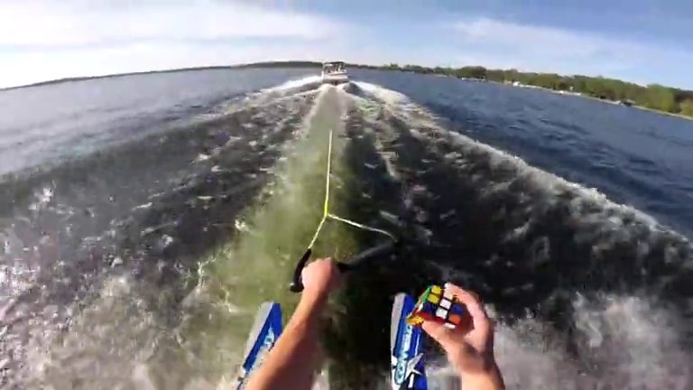 Il cubo di Rubik viene risolto mentre il prestigiatore fa sci nautico